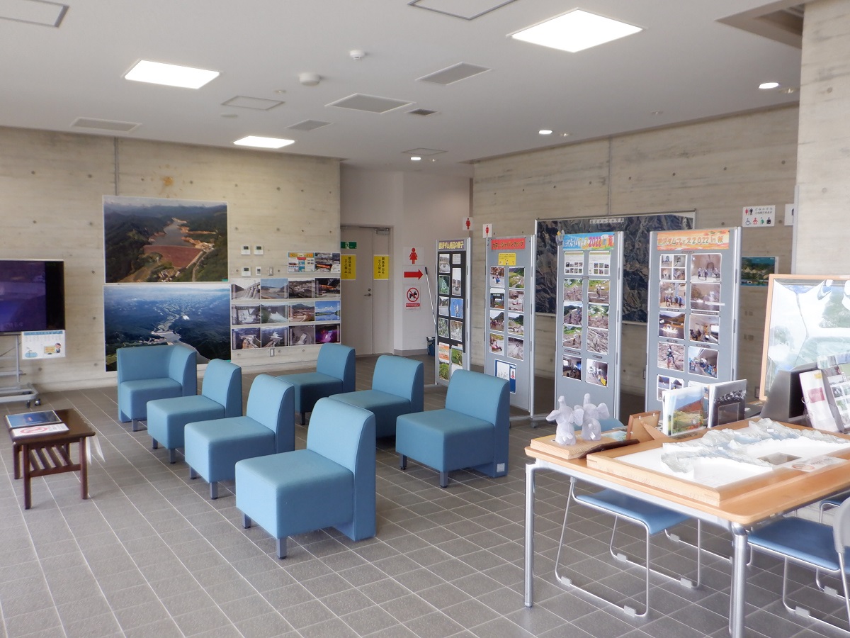 壁面とテーブルの上にパネル、風景写真、胆沢ダムの3D模型などを展示されており、一人がけのソファが7台設置されている