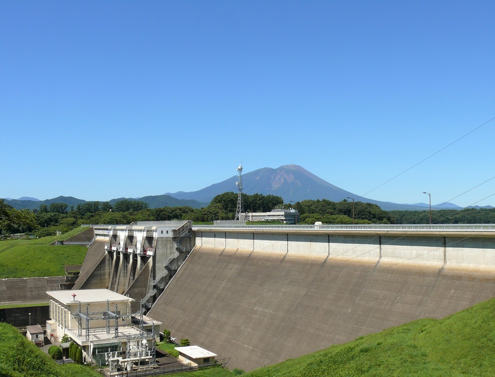 雲一つない空と、青々とした木々とともに、雄大なダム堤体が存在しています。