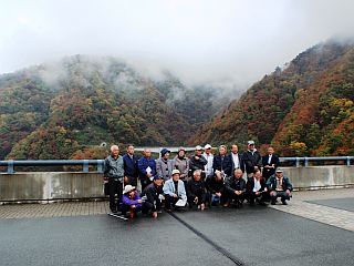 紅葉した山々を背に記念撮影を