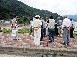 ダム堤体を歩きながら、スタッフの説明を受ける皆さん