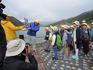 堤体（ダム本体）の上を歩きながら説明を受ける児童の皆さん