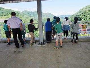 洪水吐で下流を見下ろしダムの高さを体感