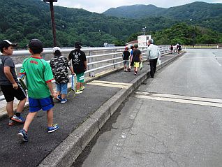 堤体上の案内広場に向かい、記念碑前で記念撮影