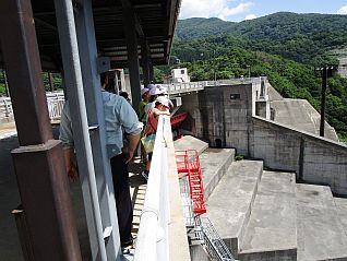 洪水吐で下流を見下ろしダムの高さを体感