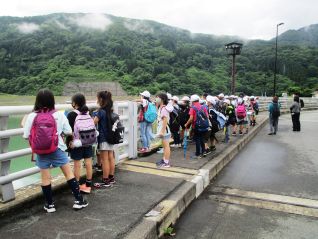 洪水吐の高さと月山湖の大きさを体感