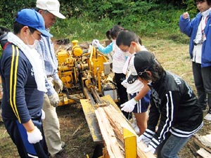 薪割り機械で炭用の木を準備