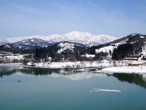 残雪が残る飯豊山と湖畔公園