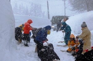 降雪の中慣れないかんじきは履くだけでも大変